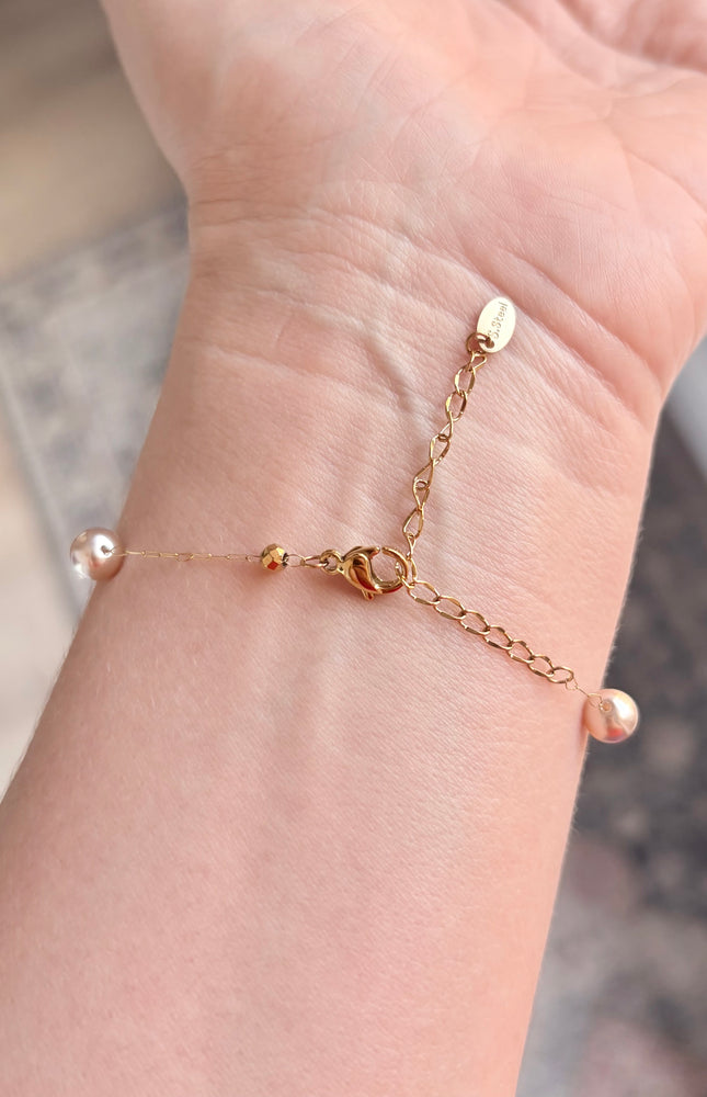 Hypoallergenic gold bracelet featuring imitation pearl accents and a secure clasp.