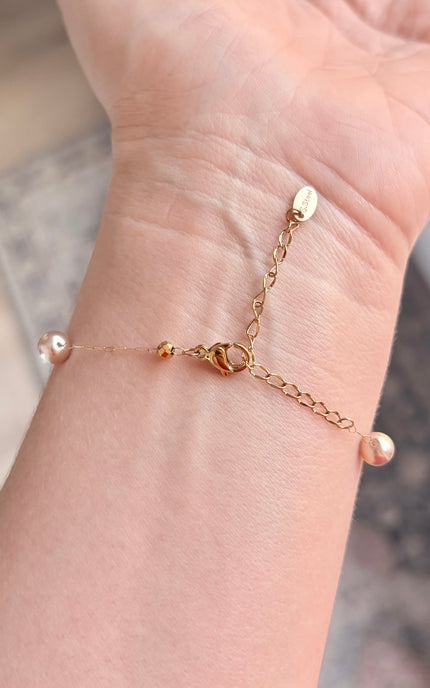 Hypoallergenic gold bracelet featuring imitation pearl accents and a secure clasp.