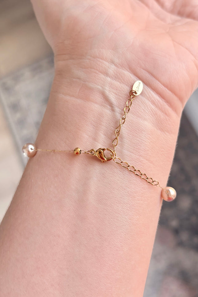 Hypoallergenic gold bracelet featuring imitation pearl accents and a secure clasp.