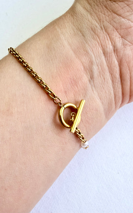 Freshwater pearl bracelet with gold toggle closure displayed on a neutral background.