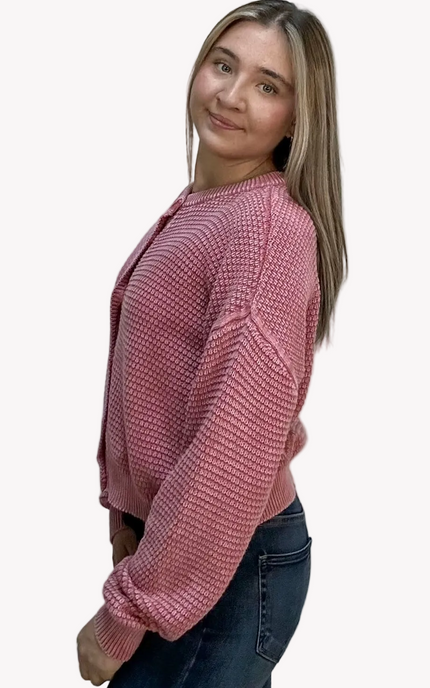 Woman wearing a pink textured sweater on a light pink background
