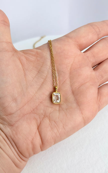 Rectangular zircon pendant necklace resting in an open palm, showing delicate scale and minimal design.