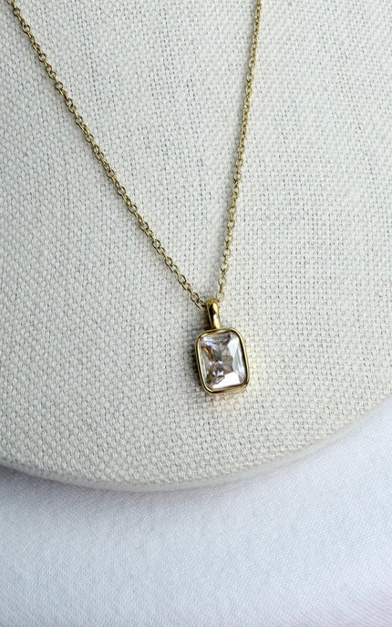 Close‑up of the small rectangular zircon pendant on a jewelry form, highlighting its subtle sparkle.