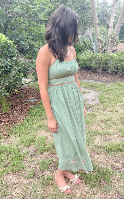 Woman in a green dress standing in a garden