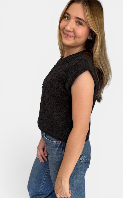 Angled side view of short sleeve textured sweater top with casual drape.
