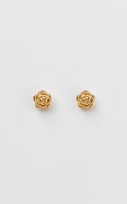 A pair of sculpted gold rose blossom stud earrings resting on a clean, soft background, showcasing their detailed texture and vintage-inspired charm.