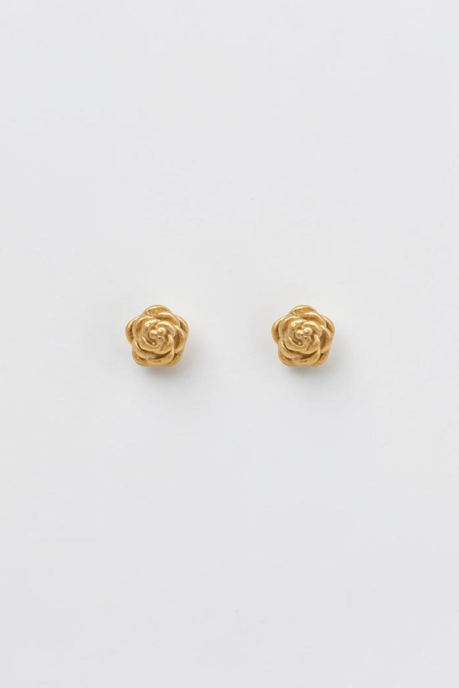 A pair of sculpted gold rose blossom stud earrings resting on a clean, soft background, showcasing their detailed texture and vintage-inspired charm.