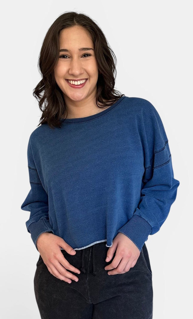 Front view of oversized denim wash sweatshirt with wide neckline and long sleeves.