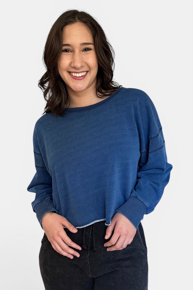 Front view of oversized denim wash sweatshirt with wide neckline and long sleeves.