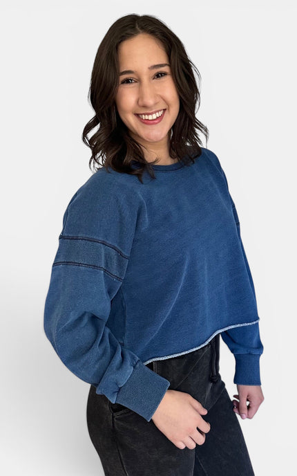 Side view of oversized denim wash sweatshirt with relaxed silhouette.