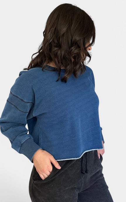 Close-up front of oversized blue denim wash pullover sweatshirt.