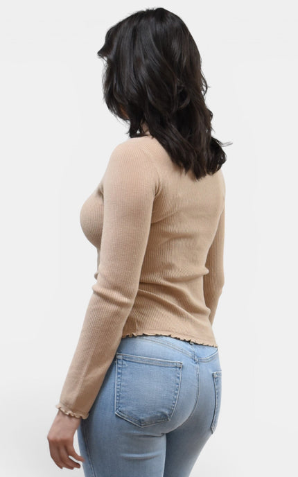 Back angled view of women's ruffle neckline sweater with front slit detail.