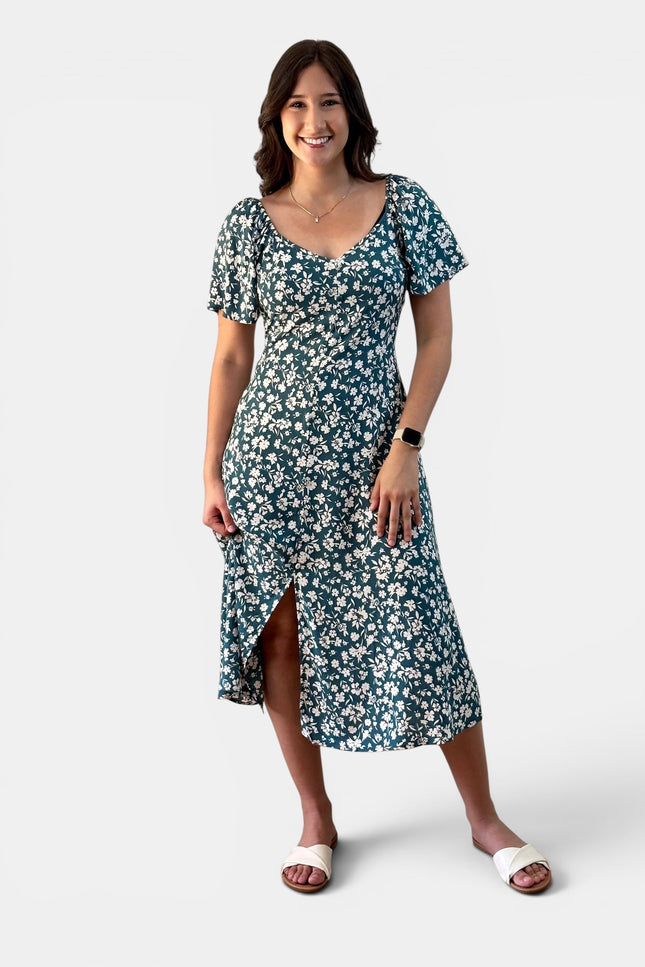Front view of a teal floral midi dress with flared sleeves and a flowy silhouette.