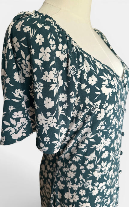 Closeup view of teal floral button-front midi dress made from breathable rayon with an easy, relaxed silhouette.