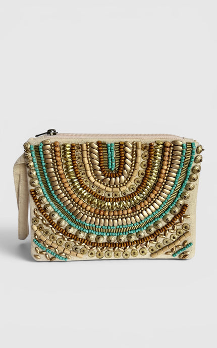 A beige clutch bag featuring intricate geometric beadwork in gold, bronze, and turquoise, with a matching beige wristlet strap on the left side, set against a light gray background.