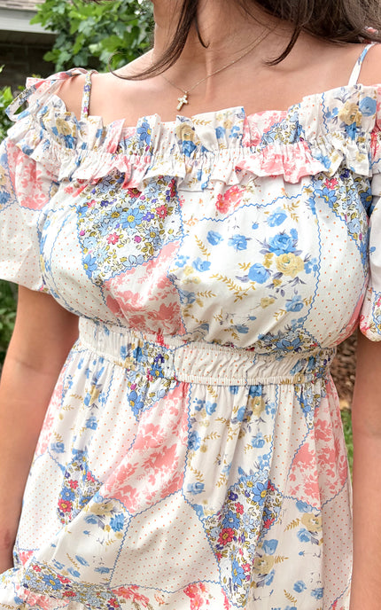 Close-up of elastic ruffled off-shoulder neckline with adjustable tying shoulder straps and short puff sleeves on floral midi dress