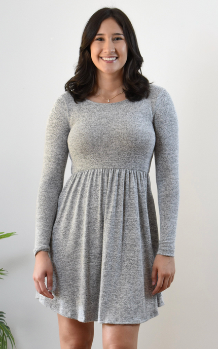 Woman wearing a gray long-sleeve dress against a white background