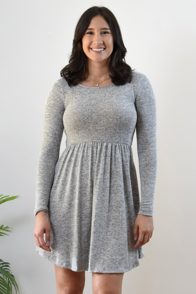 Woman wearing a gray long-sleeve dress against a white background