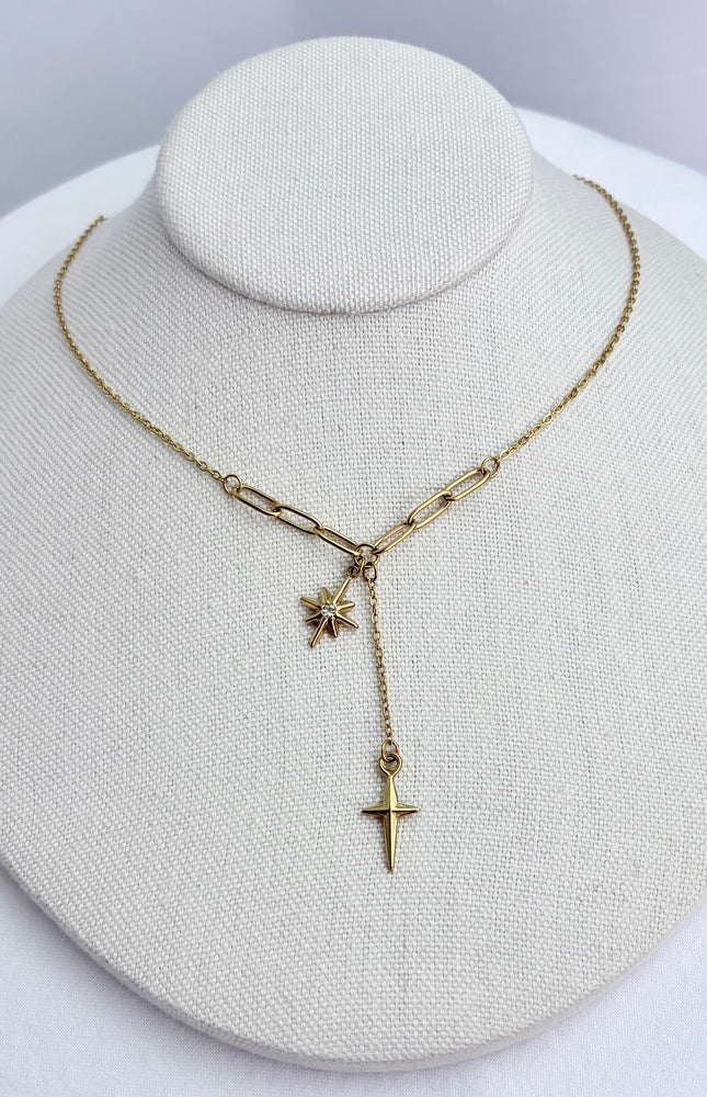 Star, cross, and tassel pendant necklace displayed on a neutral jewelry form, showing full front view and delicate drape.