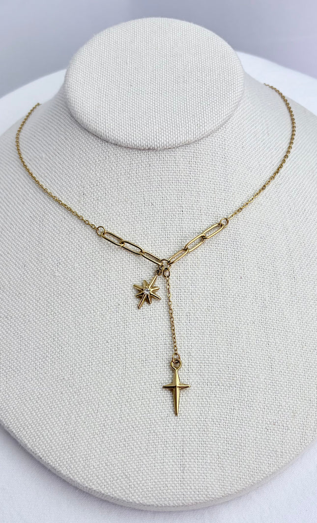 Star, cross, and tassel pendant necklace displayed on a neutral jewelry form, showing full front view and delicate drape.