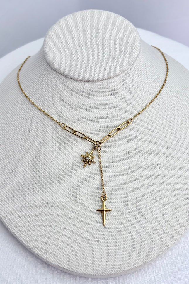 Star, cross, and tassel pendant necklace displayed on a neutral jewelry form, showing full front view and delicate drape.