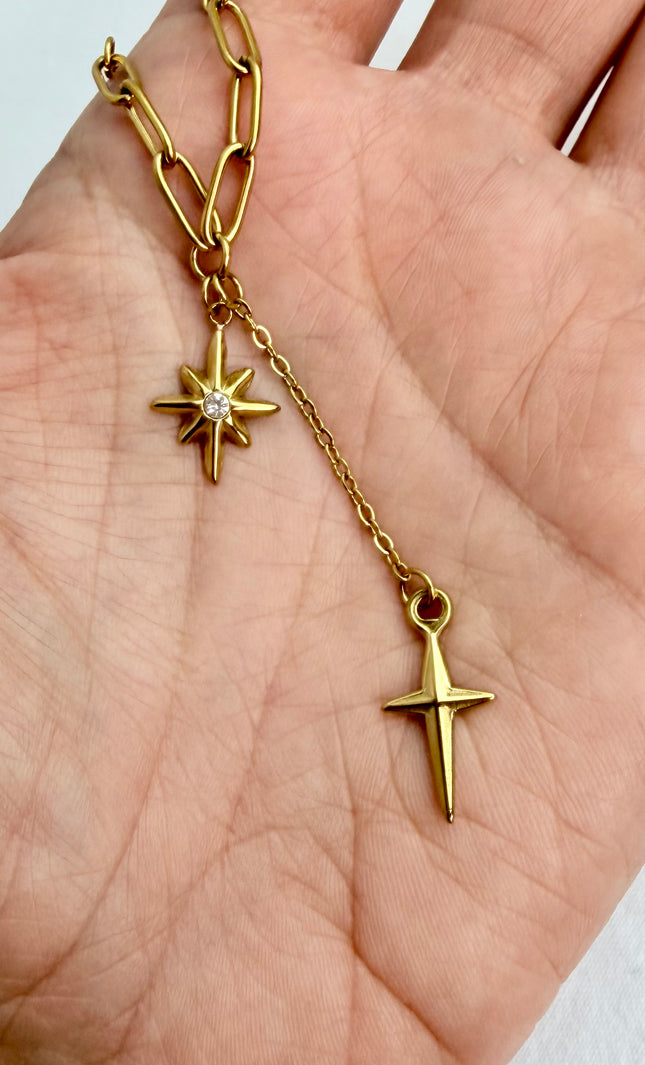 Close‑up of star, cross, and tassel pendants cradled in a hand, highlighting detail and shine.