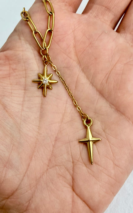 Close‑up of star, cross, and tassel pendants cradled in a hand, highlighting detail and shine.