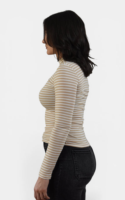 Side view of women's striped mock neck top with fitted silhouette.