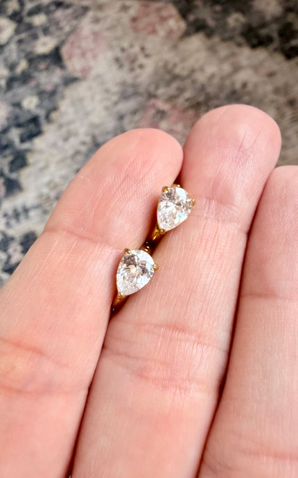 Timeless gold hoop earrings with sparkling teardrop charms for effortless styling.