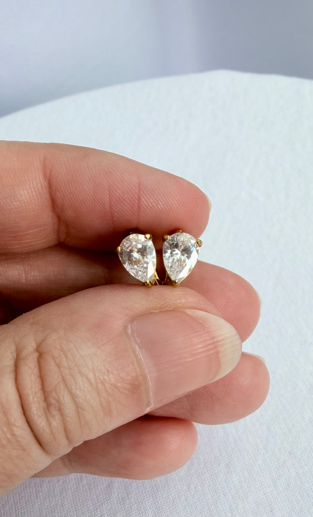 Feminine gold earrings featuring a delicate hoop and crystal pendant design.