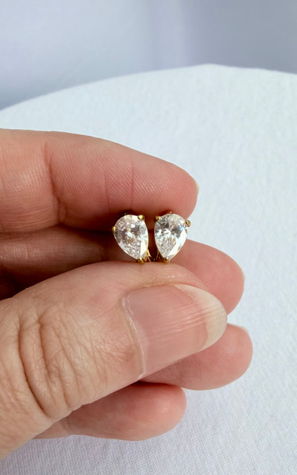 Feminine gold earrings featuring a delicate hoop and crystal pendant design.