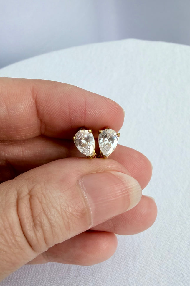 Feminine gold earrings featuring a delicate hoop and crystal pendant design.