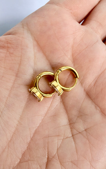 Minimalist gold earrings featuring faceted teardrop crystal charms.