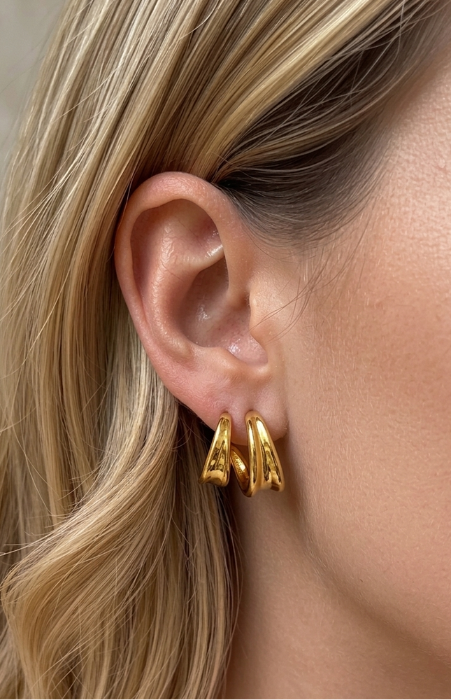 On-ear shot of double twist hoop earrings in 18k gold PVD over stainless steel showing dimensional twist detail