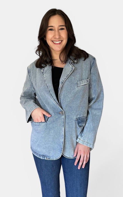 Front view of women's oversized washed denim blazer with notch lapels, chest pocket, flap pockets, and single-button closure.