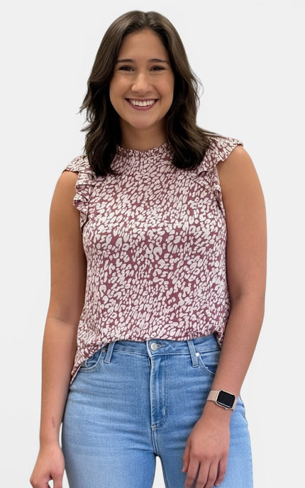 Women's sleeveless abstract animal print knit top with ruffle mock neckline and ruffle cap sleeves.