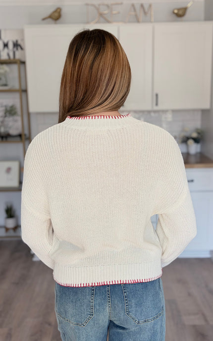 Model wearing American flag knit sweater with relaxed fit and long sleeves