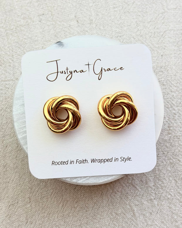 Aurelia gold knot stud earrings on soft linen background with warm natural light, timeless everyday jewelry