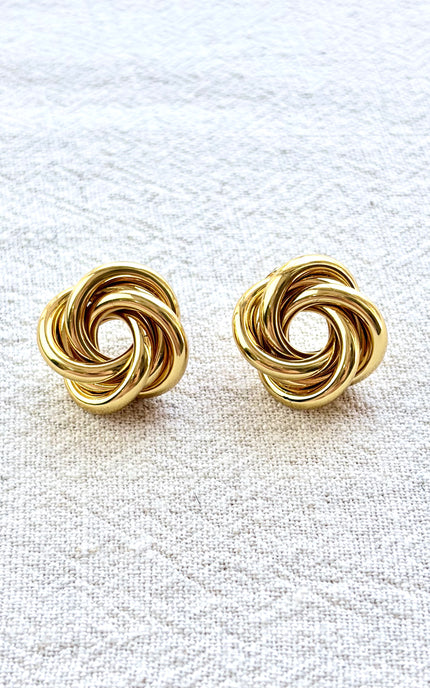 Aurelia gold knot stud earrings on soft linen background with warm natural light, timeless everyday jewelry