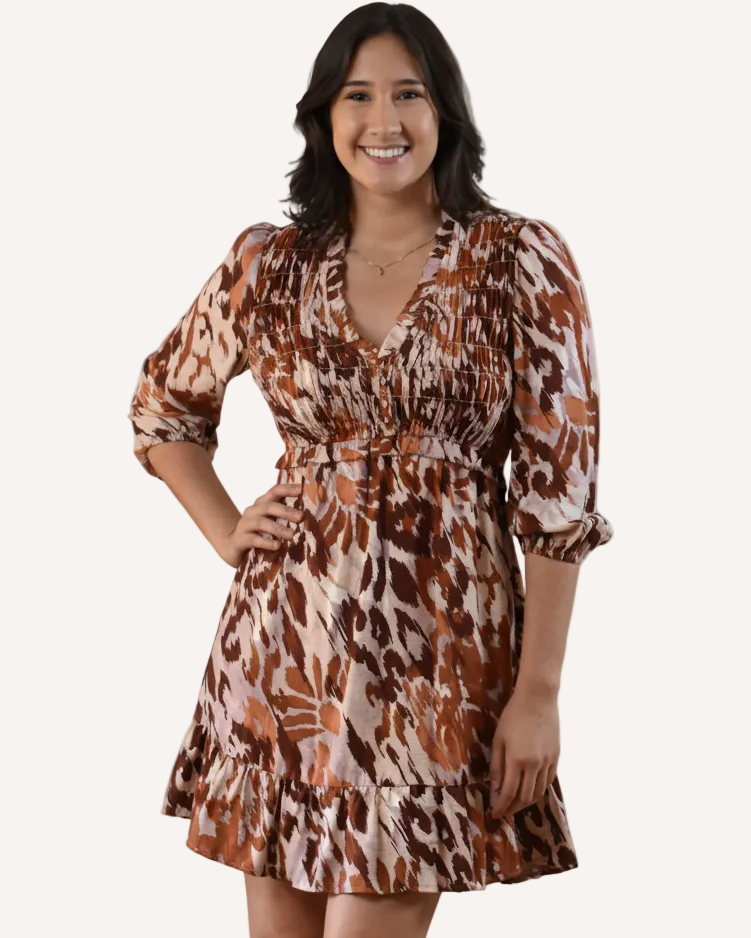 The Autumn Whisper Smocked Mini Dress in nude and brown — lightweight crinkle gauze with ruffle trim and smocked bodice from Justyna Grace Boutique.