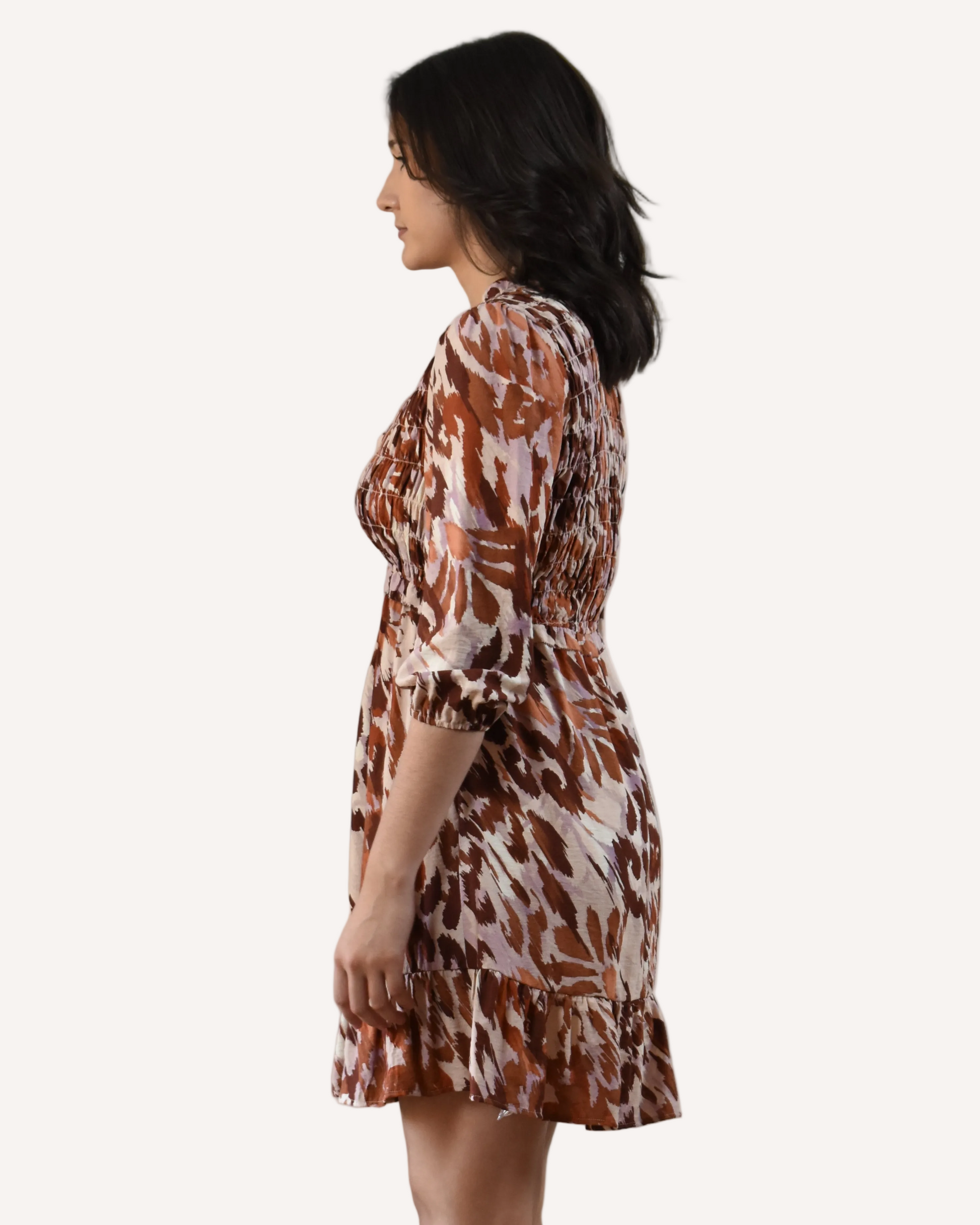 The Autumn Whisper Smocked Mini Dress in nude and brown — lightweight crinkle gauze with ruffle trim and smocked bodice from Justyna Grace Boutique.