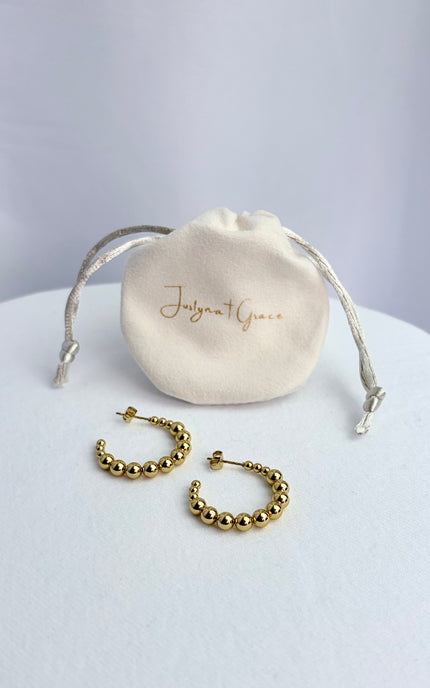 Flat lay of beaded hoop earring pair in 18k gold PVD over 316L stainless steel with classic textured design