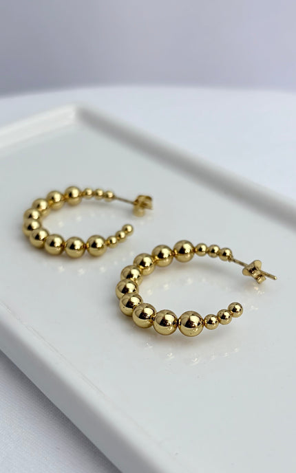 Close-up of beaded hoop earring showing dimensional bead texture and polished 18k gold PVD finish over stainless steel