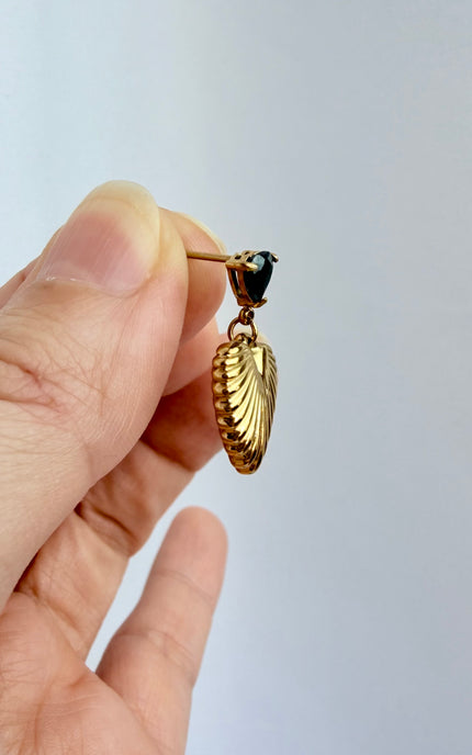 Close-up of black cubic zirconia heart and textured gold drop earring showing 18k gold PVD finish and dimensional detail
