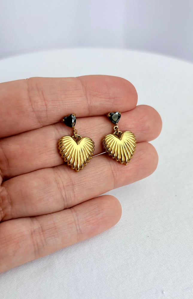 Close-up of black cubic zirconia heart and textured gold drop earring showing 18k gold PVD finish and dimensional detail