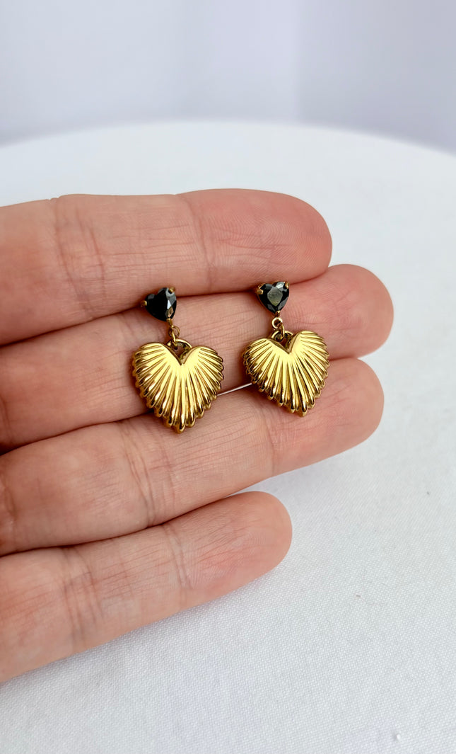Close-up of black cubic zirconia heart and textured gold drop earring showing 18k gold PVD finish and dimensional detail
