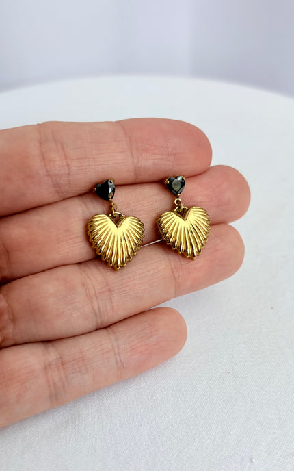Close-up of black cubic zirconia heart and textured gold drop earring showing 18k gold PVD finish and dimensional detail