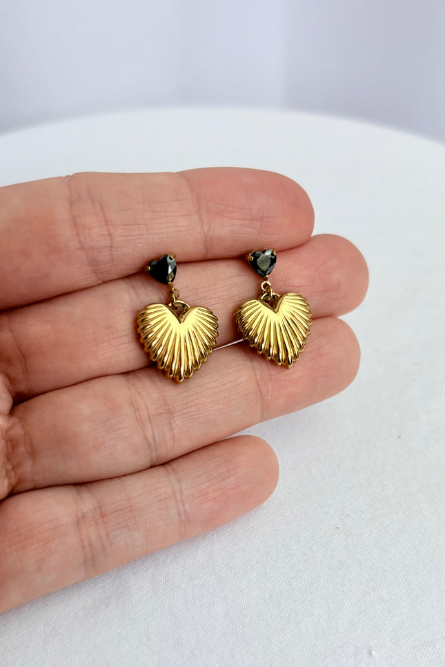Close-up of black cubic zirconia heart and textured gold drop earring showing 18k gold PVD finish and dimensional detail
