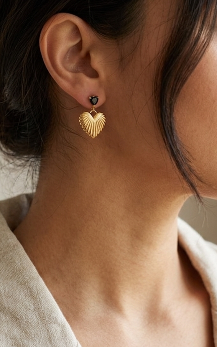 Black crystal heart drop earrings with textured 18k gold detail worn on model showing feminine, edgy styling