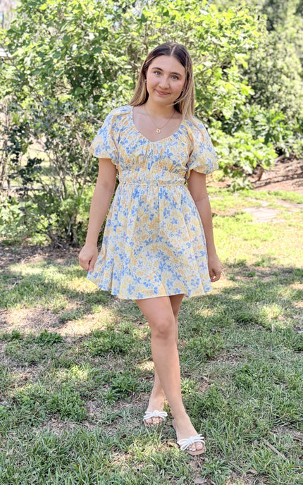 Woman in Bloom Bubble Sleeve Dress styled casually with simple sandals for spring garden setting, showcasing comfortable elasticated waist and airy cotton fabric